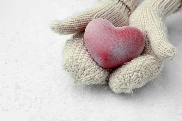 Руки женщины в рукавицах с красным сердцем, крупным планом — стоковое фото
