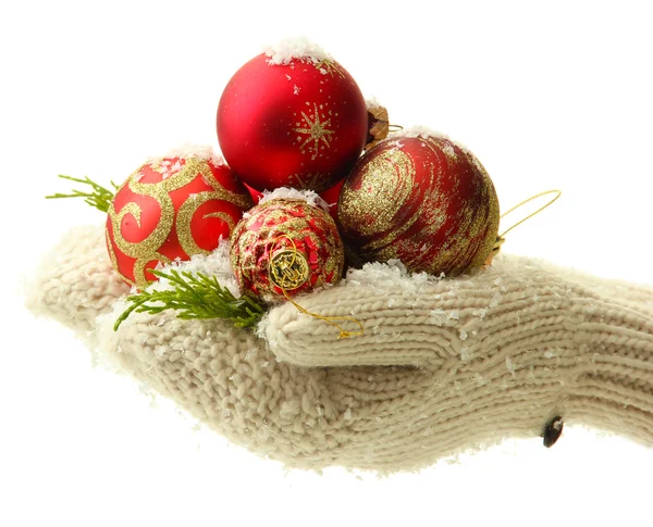 Vrouwelijke handen in wanten kerstboom ballen, op een achtergrond met kleur — Stockfoto