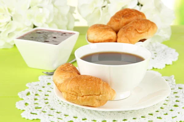 Croissant gustosi e una tazza di caffè in tavola primo piano — Foto Stock
