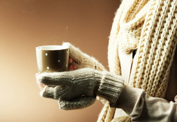 色の背景上の温かい飲み物と女性の手 — ストック写真