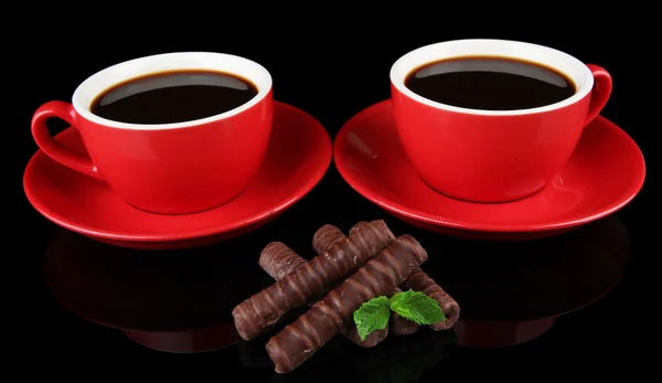 Red cups of strong coffee and chocolate bars isolated on black — Stock Photo, Image