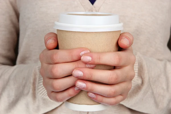 Hot drink in paper cup in hands close up — Stock Photo, Image