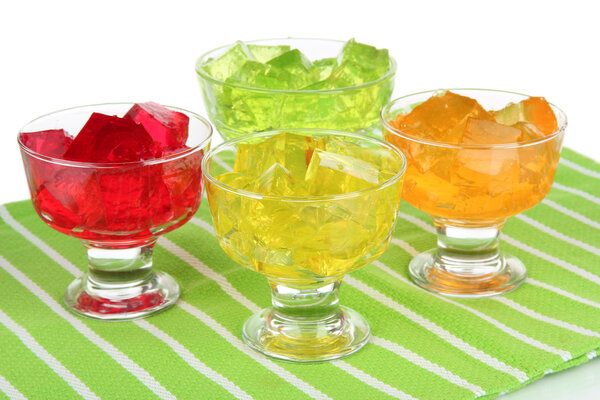 Tasty jelly cubes in bowls on table on white background