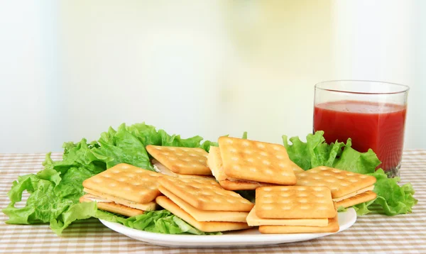 Sandwich crackers with cheese and tomato juice on tablecloth on bright background — Stock Photo, Image
