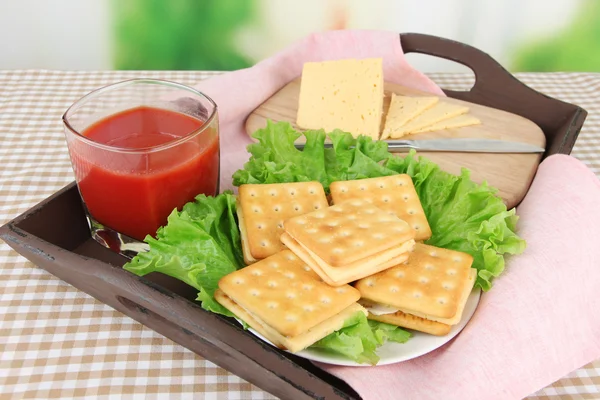 Sandwich crackers with cheese and tomato juice on tablecloth on bright background — Stock Photo, Image