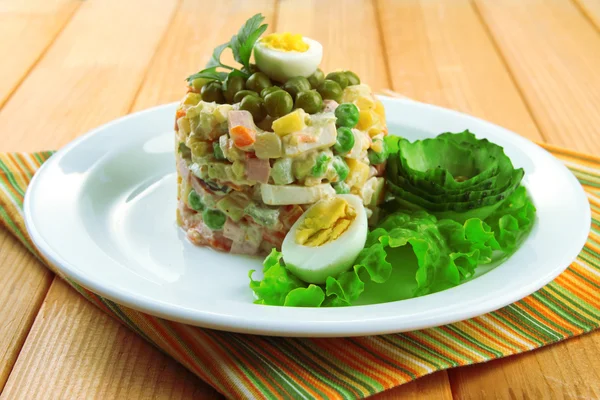 Salada tradicional russa Olivier, em guardanapo de cor, em fundo de madeira — Fotografia de Stock