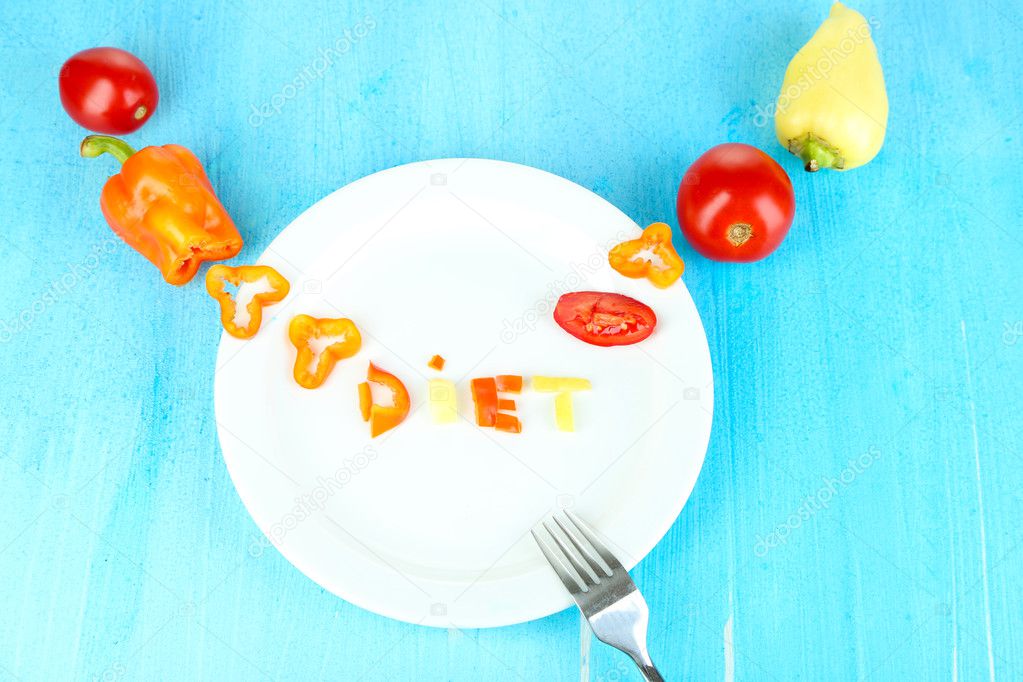 Word diet lined vegetables on plate on wooden table close-up