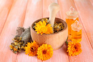 ilaç şişeleri ve ahşap zemin üzerine calendula çiçekler