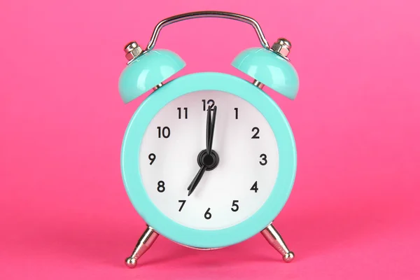 Relógio de alarme azul no fundo rosa — Fotografia de Stock
