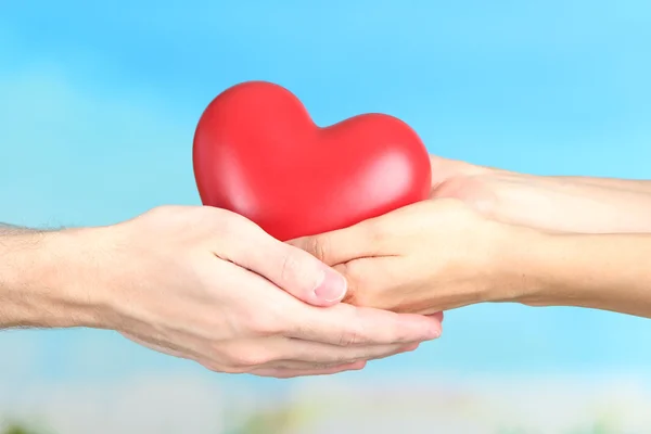Сердце в руках на фоне облаков — стоковое фото