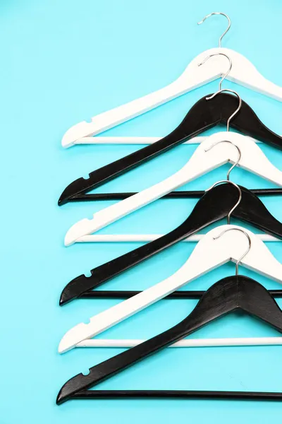 Cabides de roupas preto e branco no fundo de cor — Fotografia de Stock