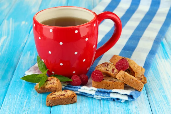 Taza de té con galletas y frambuesas en primer plano de la mesa — Foto de Stock