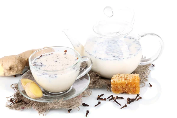 Tetera y taza de té con leche y especias sobre tela de saco aislada sobre blanco — Foto de Stock