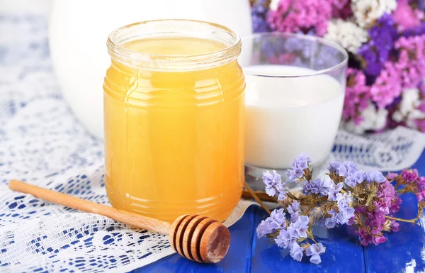 Honung och mjölk på blå träbord närbild — Stockfoto