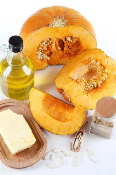 Cut pumpkin with ingredients for cooking on wooden table close-up — Stock Photo, Image