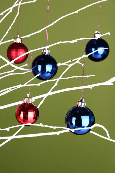 Jouets de Noël suspendus sur la branche sur fond vert — Photo