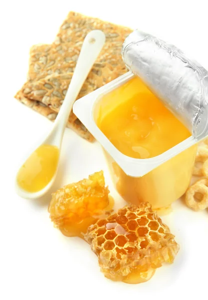 Tasty dessert in open plastic cup and honey combs, isolated on white — Stock Photo, Image