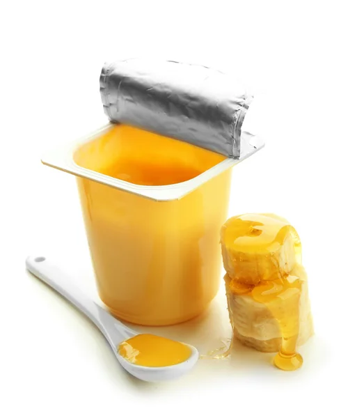Välsmakande efterrätt i öppna plastmugg och banan, isolerad på vit — Stockfoto