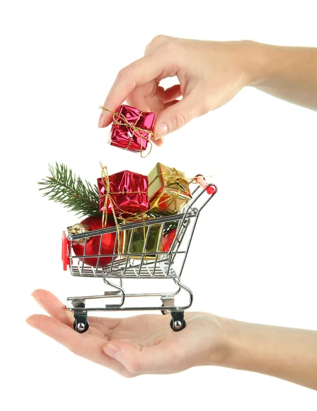Hand hält Weihnachtsgeschenke im Einkaufswagen, isoliert auf weiß — Stockfoto