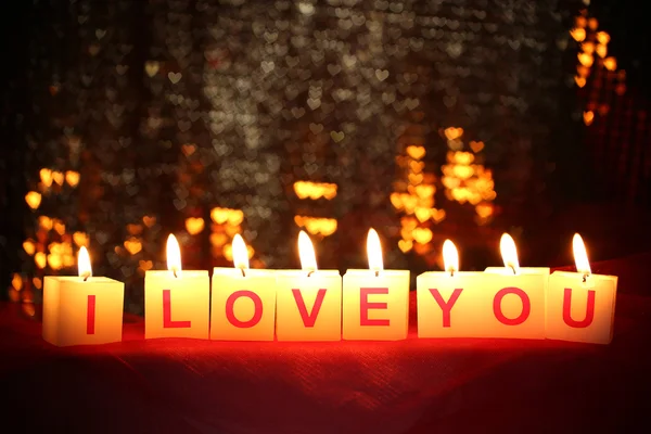 Velas con letrero impreso TE AMO, sobre fondo de luces borrosas —  Fotos de Stock