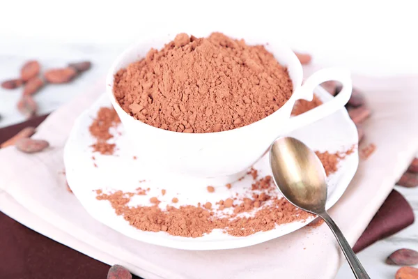 Kakaopulver i cup på servett på träbord — Stockfoto