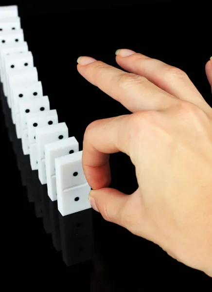 Hand pushing dominoes isolated on black — Stock Photo, Image