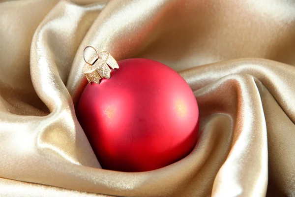 Belle boule de Noël sur tissu satiné doré — Photo