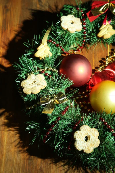 Grinalda de Natal decorada com biscoitos sobre fundo de madeira — Fotografia de Stock