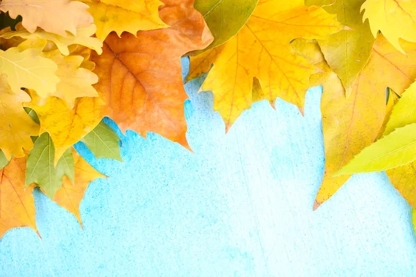 Bright autumn leafs on blue wooden table — Stock Photo, Image