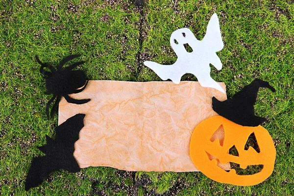 Vieux papier avec décorations d'Halloween sur fond de mousse verte — Photo