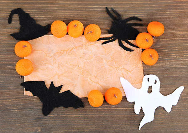Gri ahşap zemin üzerinde halloween süslemeleri ile eski kağıt — Stok fotoğraf