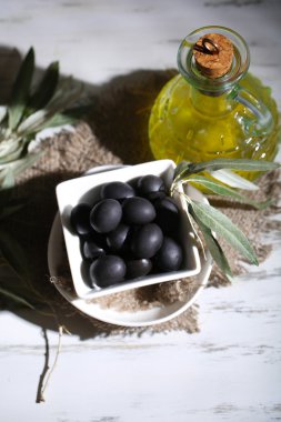 zeytinyağı ve zeytin ahşap masa üstünde çul üzerinde kase