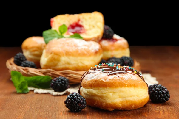 Leckere Donuts mit Schokolade und Beeren auf Holztisch — Stockfoto