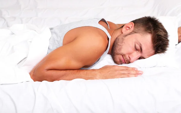 Schöner junger Mann im Bett — Stockfoto