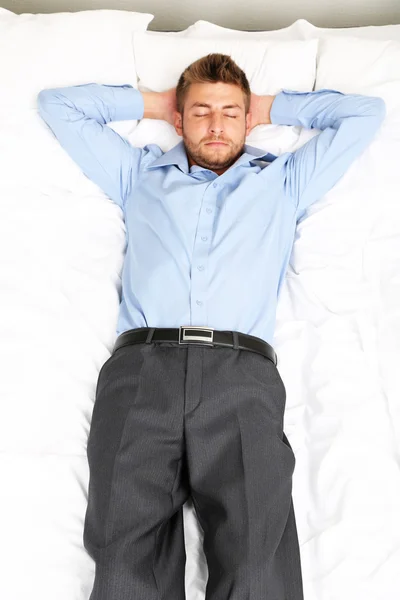 Pohledný mladý muž v posteli — Stock fotografie