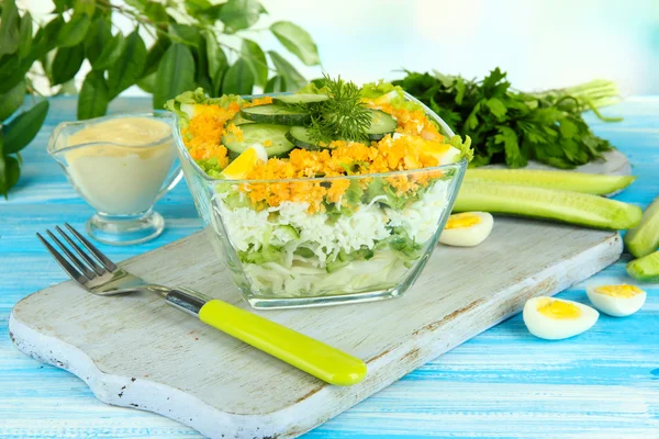 Deliziosa insalata con uova, cavolo e cetrioli sul tavolo di legno blu — Foto Stock
