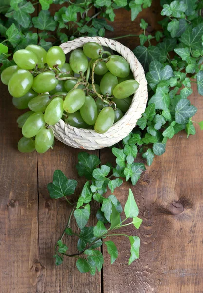 Ripe green grapes in basket on wooden table close-up — Stock Photo, Image