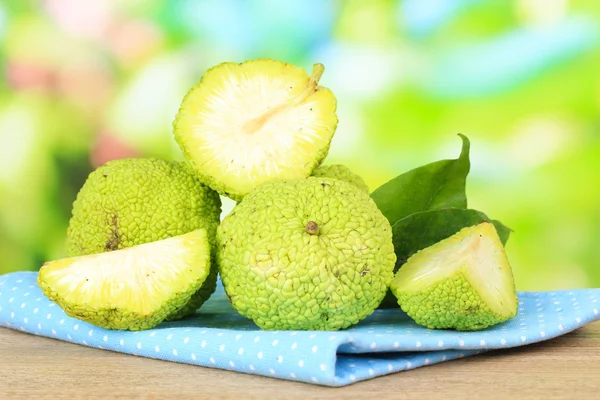 桑橙果实 （maclura pomifera） 在篮子里，木制的桌子，对自然背景上 — 图库照片