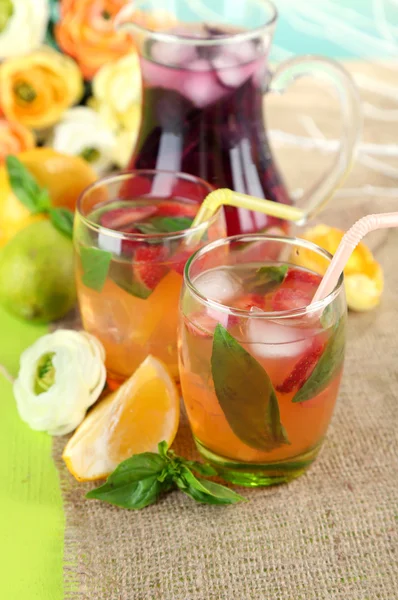 Rote Basilikumlimonade in Krug und Glas, auf Holztisch, auf hellem Hintergrund — Stockfoto