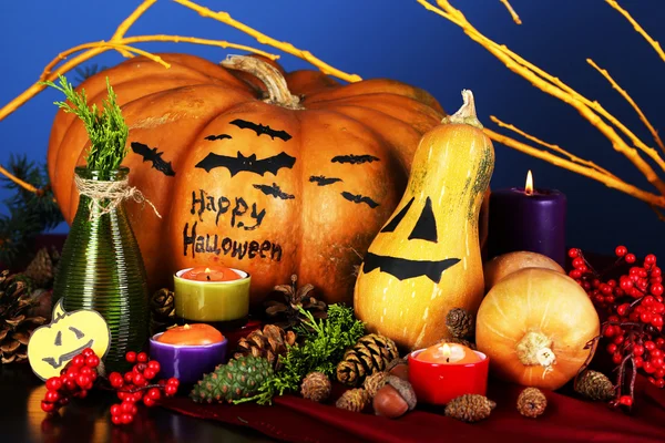 Samenstelling voor halloween met pompoenen en kaarsen op blauwe achtergrond — Stockfoto