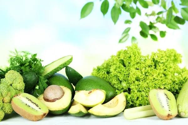 Färska grönsaker och frukter, på träbord, på ljus bakgrund — Stockfoto