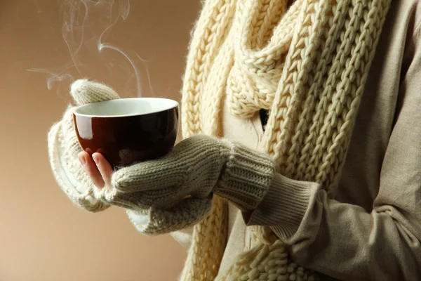 Female hands with hot drink, on color background — Stock Photo, Image