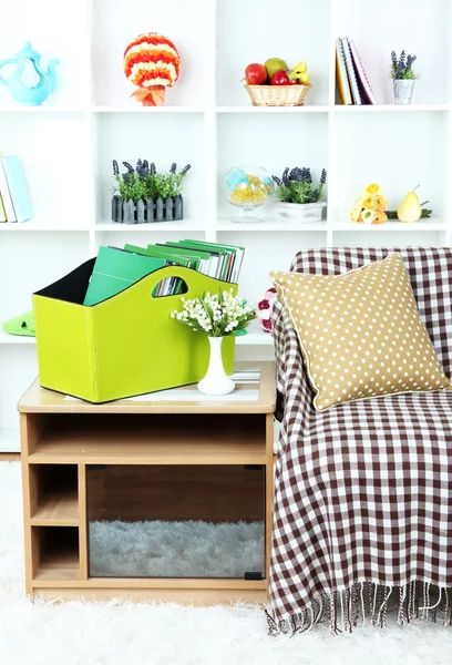 Magazines and folders in green box on bedside table in room — Stock Photo, Image