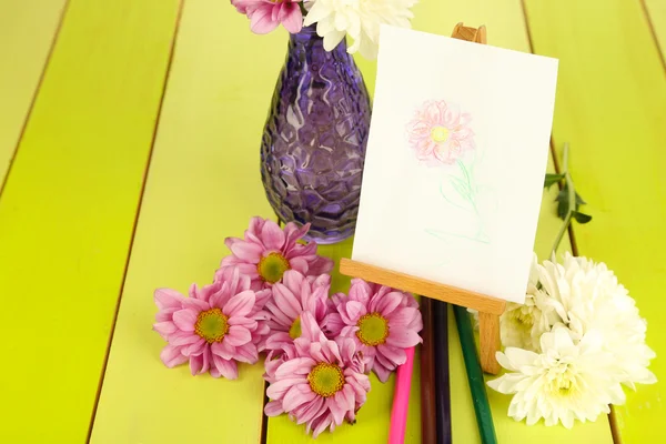 Blumen und kleine Staffelei mit Bild — Stockfoto