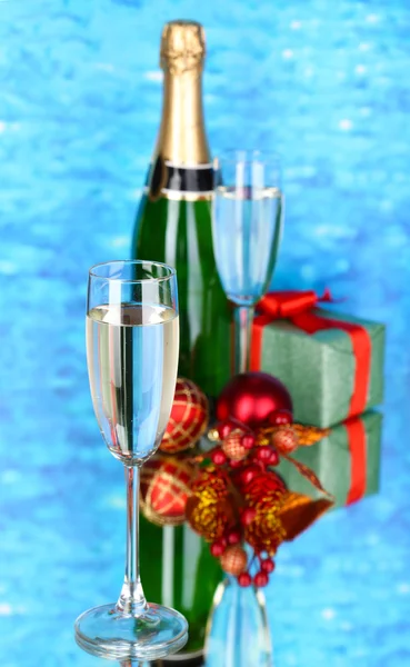 Şampanya bardakları ve Noel topları üzerinde mavi arka plan ile — Stok fotoğraf