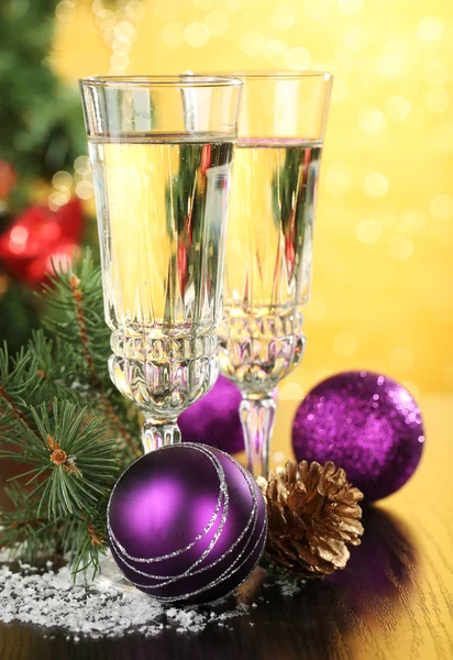 Composition with Christmas decorations and two champagne glasses, on bright background — Stock Photo, Image