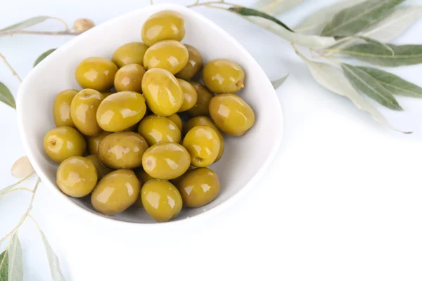 Oliven in Schüssel mit Zweig isoliert auf weiß — Stockfoto