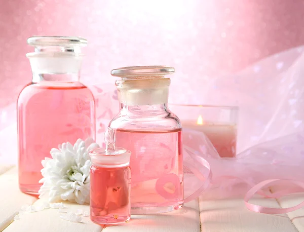 Bottiglie di vetro con essenza di colore, su sfondo rosa — Foto Stock