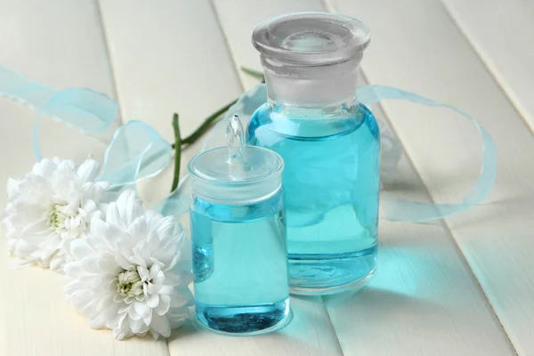 Glass bottles with color essence, on wooden background — Stock Photo, Image