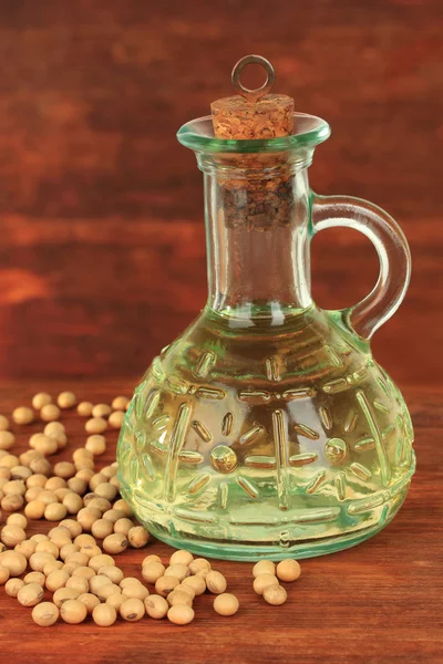 Soy beans and oil on wooden background — Stok fotoğraf